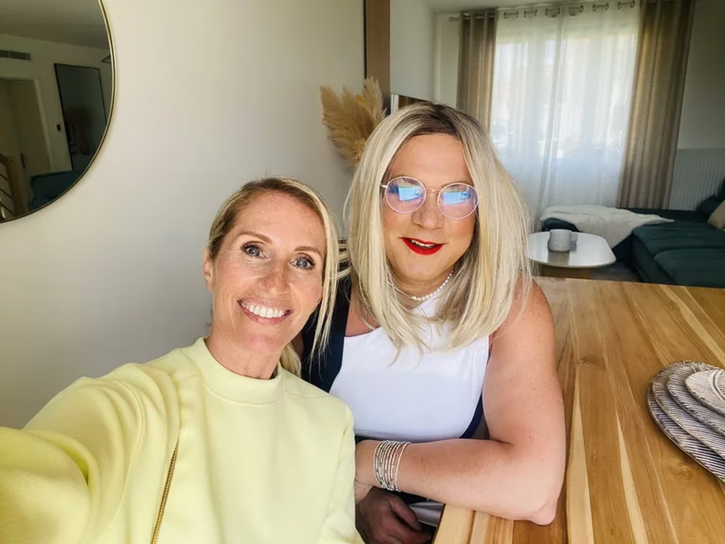 Laura, rayonnante après une séance de maquillage avec Jennifer, sa maquilleuse experte pour travestis, transsexuelles et transgenres. Ensemble, elles capturent un moment de complicité et de féminité assumée, reflétant la beauté de vivre entre deux mondes avec confiance et élégance.