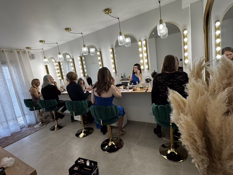 cours collectif de maquillage chez Transbeauté, dans un espace élégant et lumineux, spécialement pensé pour la féminisation et l’accompagnement en beauté. Plusieurs personnes travesties sont installées face à de grands miroirs éclairés, en pleine séance de maquillage collectif. L’ambiance est à la fois chic, bienveillante et conviviale, propice à l’apprentissage, au partage et à la confiance en soi. Ce type d’atelier permet de progresser en maquillage travesti, de travailler son image, et de vivre un vrai moment d’échange autour du travestissement, de la transformation et de l’expression de sa féminité