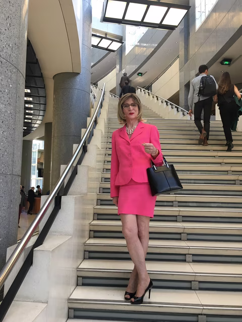 Femme transgenre en tailleur rose sur les marches de l'Opera Bastille Sur les marches de l’Opéra Bastille