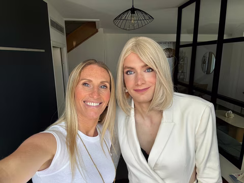 Jennifer aux côtés d'une cliente blonde dans une atmosphère douce et cosy, en tenue de préparation avant mise en beauté.