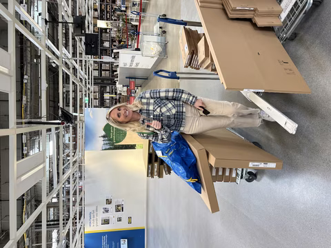 Jennifer, rayonnante et pleine d'enthousiasme, se tient dans les allées d'IKEA, prête à concrétiser son rêve d'agrandir le studio Transbeauté. Avec un pouce levé et un sourire éclatant, elle montre sa détermination et son excitation. Autour d'elle, des chariots chargés de grandes boîtes et d'un sac bleu IKEA, symboles des nouveaux équipements qui transformeront le studio en un espace encore plus accueillant. Cette étape marque un moment clé dans l'évolution de Transbeauté, portée par la passion et l'engagement de Jennifer pour ses clientes